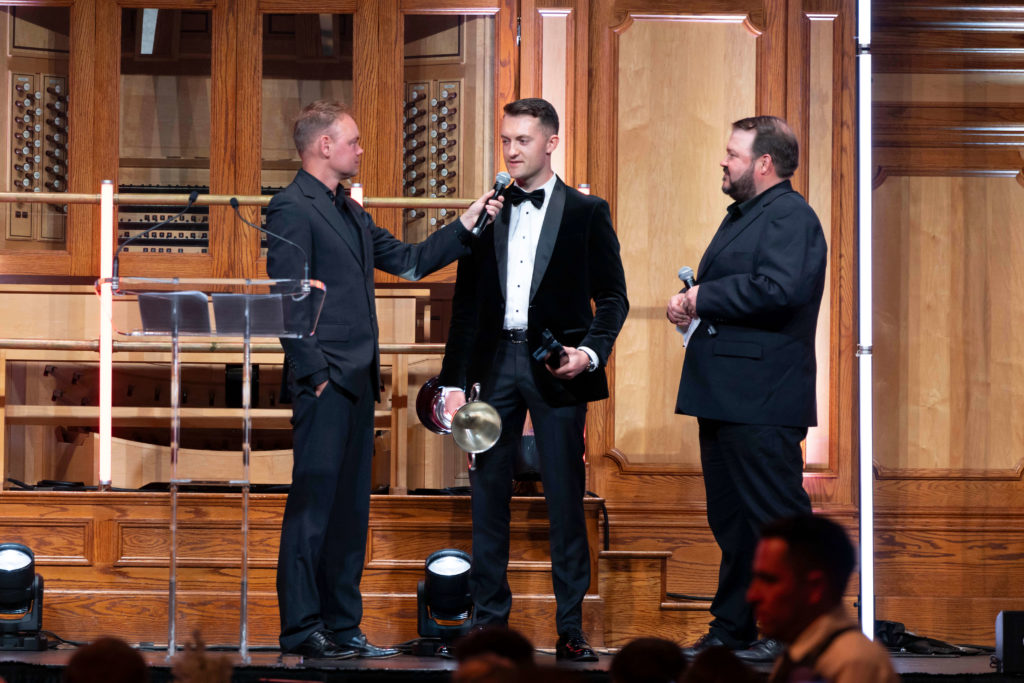 Dexion Victoria sponsored driver Dylan being interviewed on stage while holding his championship trophy at a formal awards presentation event.