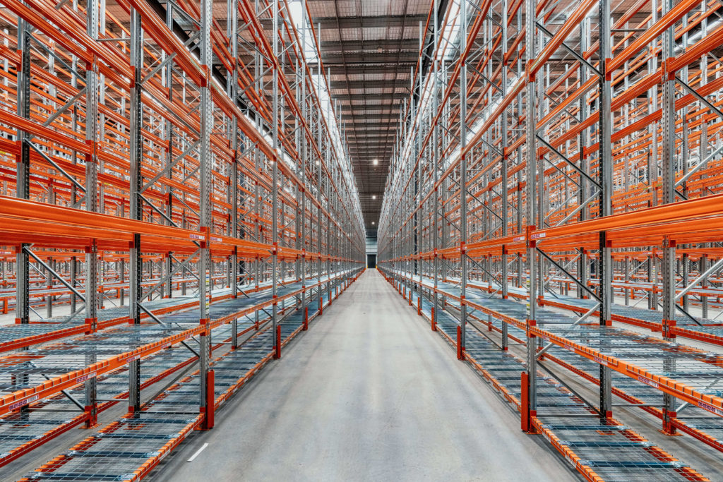 High-capacity selective pallet racking installation completed by Dexion Victoria for Amer Sports' new 15,000sqm distribution centre in Cranbourne West, Victoria. The warehouse fit-out features multiple aisles of pallet racking with mesh decking, designed to maximise storage capacity, improve operational efficiency, and support future growth.